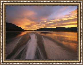 Raymond Gehman Framed Prints - A Jet Boat Leaves a Wake in The Mackenzie River at Sunset by Raymond Gehman