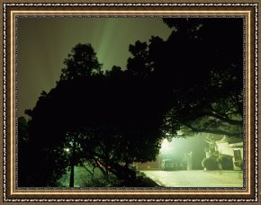 Raymond Gehman Framed Prints - Light Shining in Rays Behind Silhouetted Trees at Night by Raymond Gehman