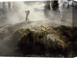 Woman at a Hot Spring Hotel Canvas Prints - Venting Steam Veils a Hiker Skirting a Hot Spring in The Bechler Backcountry by Raymond Gehman