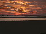 Between Geest And Marsh Prints - Sunset Over a Salt Marsh with Cordgrass by Raymond Gehman